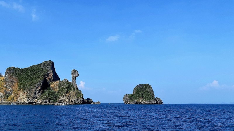 Ocean with two rocky islands under a clear blue sky