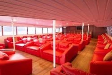 Spacious room with rows of red sofas and natural light from large windows