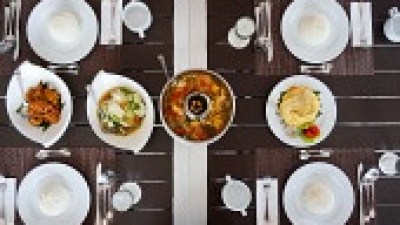 Table set with white plates, cutlery, and assorted dishes at the center.