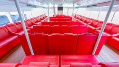 Spacious interior with rows of bright red seats and large windows.